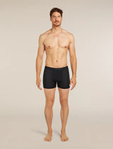 A shirtless male model standing against a plain light beige studio background, wearing black boxer briefs. - Icebreaker Merino Blend 125 Cool-Lite Anatomica Boxers (Men's) - Black