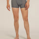 A man wearing heather gray boxer briefs with a dark gray waistband featuring the 'lebrecher' brand logo, shown from the waist down against a light beige studio background. - Icebreaker Merino Blend 125 Cool-Lite Anatomica Boxers (Men's) - Gritstone Heather