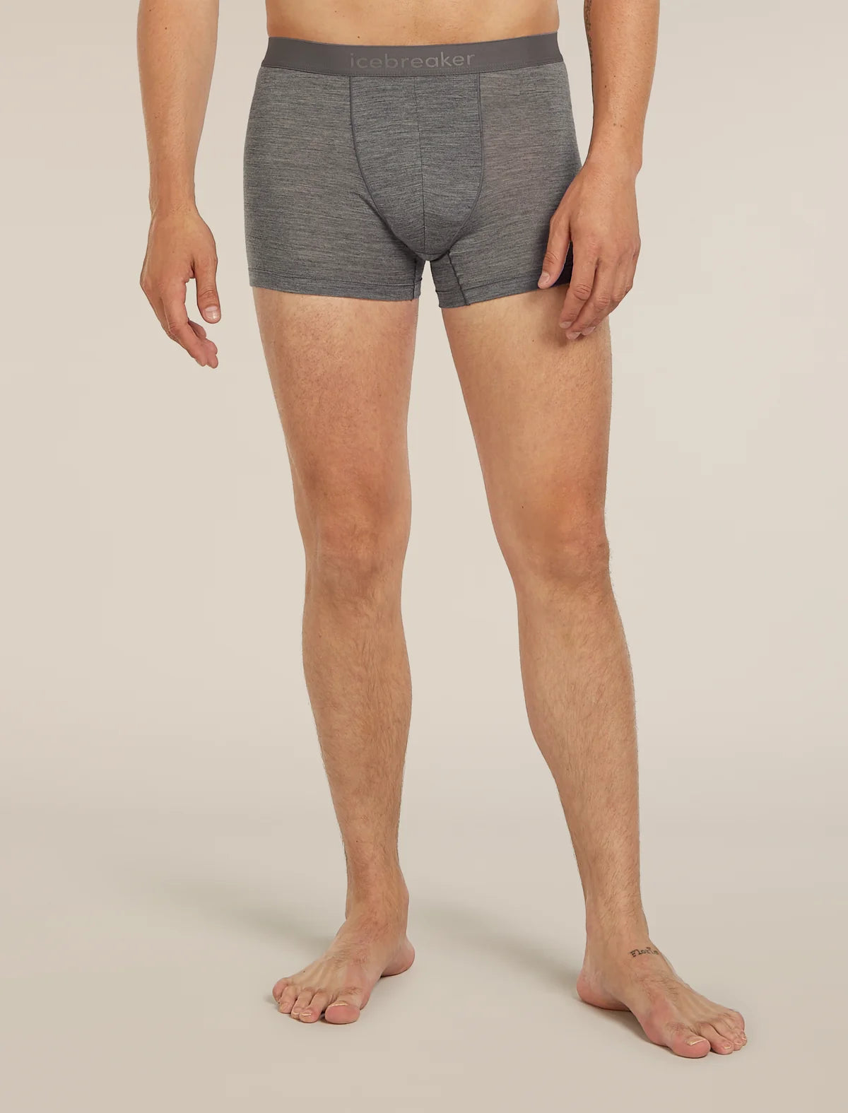 A man wearing heather gray boxer briefs with a dark gray waistband featuring the 'lebrecher' brand logo, shown from the waist down against a light beige studio background. - Icebreaker Merino Blend 125 Cool-Lite Anatomica Boxers (Men's) - Gritstone Heather