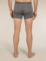 A man viewed from the back wearing heather gray boxer briefs, standing barefoot against a plain light beige studio background. - Icebreaker Merino Blend 125 Cool-Lite Anatomica Boxers (Men's) - Gritstone Heather