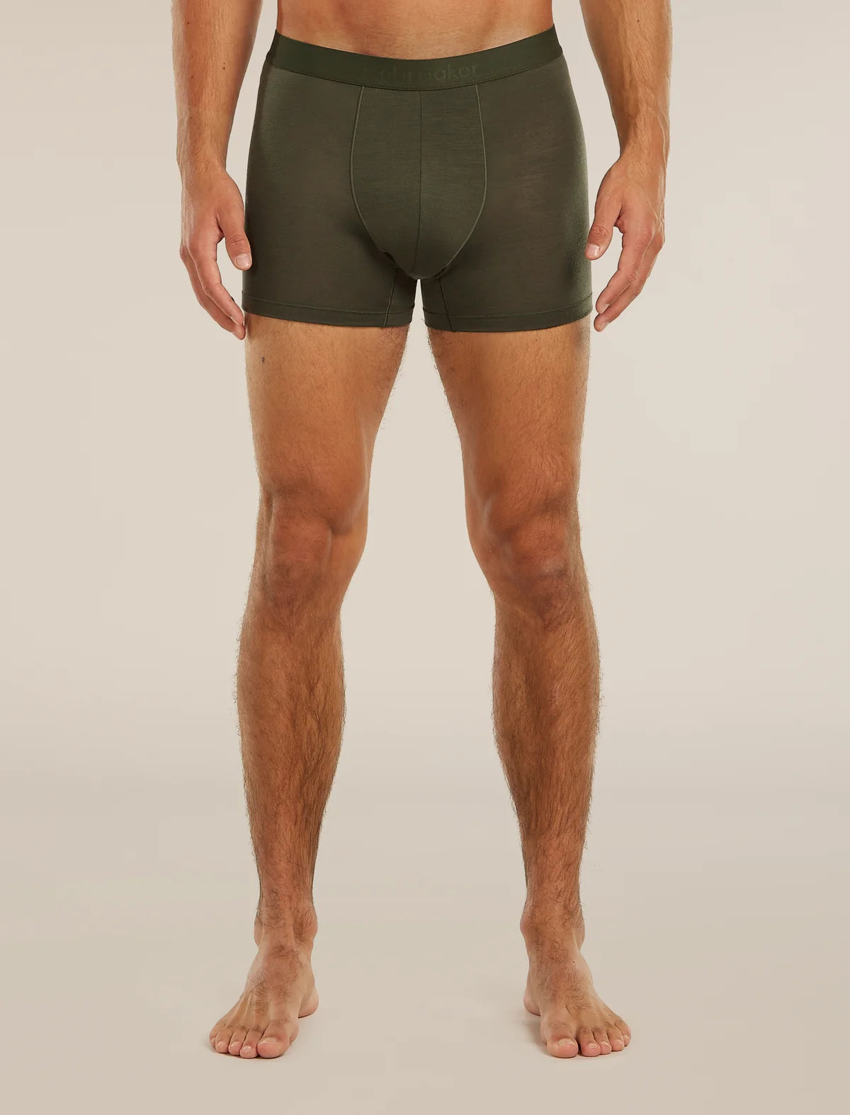 A man wearing dark olive green boxer briefs, shown from the waist down against a plain light beige studio background. - Icebreaker Merino Blend 125 Cool-Lite Anatomica Boxers (Men's) - Dark Loden