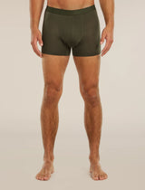 A man wearing dark olive green boxer briefs, shown from the waist down against a plain light beige studio background. - Icebreaker Merino Blend 125 Cool-Lite Anatomica Boxers (Men's) - Dark Loden