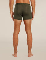 A man viewed from the back wearing olive green boxer briefs, standing barefoot against a plain light beige studio background. - Icebreaker Merino Blend 125 Cool-Lite Anatomica Boxers (Men's) - Dark Loden