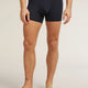 A man wearing dark navy blue boxer briefs, shown from the waist down against a light beige studio background. The brand name 'celery' is subtly printed on the front waistband. - Icebreaker Merino Blend 125 Cool-Lite Anatomica Boxers (Men's) - Midnight Navy