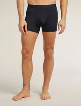 A man wearing dark navy blue boxer briefs, shown from the waist down against a light beige studio background. The brand name 'celery' is subtly printed on the front waistband. - Icebreaker Merino Blend 125 Cool-Lite Anatomica Boxers (Men's) - Midnight Navy