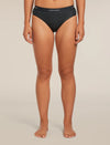 A model wearing black underwear from the waist down, standing against a neutral beige studio background. The brand name 'krelvaker' is visible on the waistband. - Icebreaker Merino Blend 125 Cool-Lite Sprite Hipster (Women's) - Black