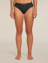A model wearing black underwear from the waist down, standing against a neutral beige studio background. The brand name 'krelvaker' is visible on the waistband. - Icebreaker Merino Blend 125 Cool-Lite Sprite Hipster (Women's) - Black