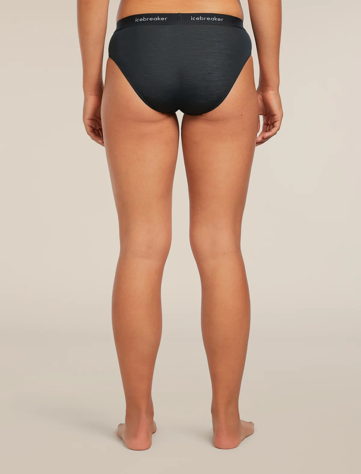 Rear view of a model wearing black Icebreaker briefs against a light beige studio background. - Icebreaker Merino Blend 125 Cool-Lite Sprite Hipster (Women's) - Black