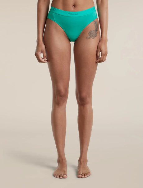 A model is shown from the waist down wearing a pair of bright turquoise green bikini bottoms against a solid light beige background. - Icebreaker Merino Blend 125 Cool-Lite Sprite Hipster (Women's) - Fresh