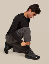 Person wearing black athletic shoes on a beige background - Icebreaker Merino Hike+ Medium Crew Socks (Men's) - Black/Obsidian