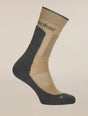 A single mid-calf athletic sock shown on a ghost mannequin against a solid light beige background. The sock features a beige knit body with a dark gray heel, toe, and ribbed cuff, and has the brand name 'saker' printed in dark gray on the upper calf. - Icebreaker Merino Hike+ Medium Crew Socks (Men's) - Cumin/Obsidian