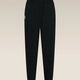 Black jogger-style pants with an elastic waistband and a small white embroidered logo on the left hip, shown against a light beige gradient background. - Icebreaker Merino Blend 150 Drift Pants (Women's) - Black