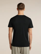 A man viewed from the back wearing a plain black short-sleeve crew-neck t-shirt and light beige trousers, standing against a solid light beige background. - Icebreaker Merino 150 Tech Lite Short Sleeve T-Shirt Range Stripes (Men's) - Black