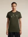 A woman modeling an olive green short-sleeve t-shirt with a graphic of four flying birds in light gray on the chest, set against a plain beige background. - Icebreaker Merino 150 Tech Lite Short Sleeve T-Shirt Bird Transit (Women's) - Dark Loden