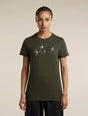 A woman modeling an olive green short-sleeve t-shirt with a graphic of four flying birds in light gray on the chest, set against a plain beige background. - Icebreaker Merino 150 Tech Lite Short Sleeve T-Shirt Bird Transit (Women's) - Dark Loden