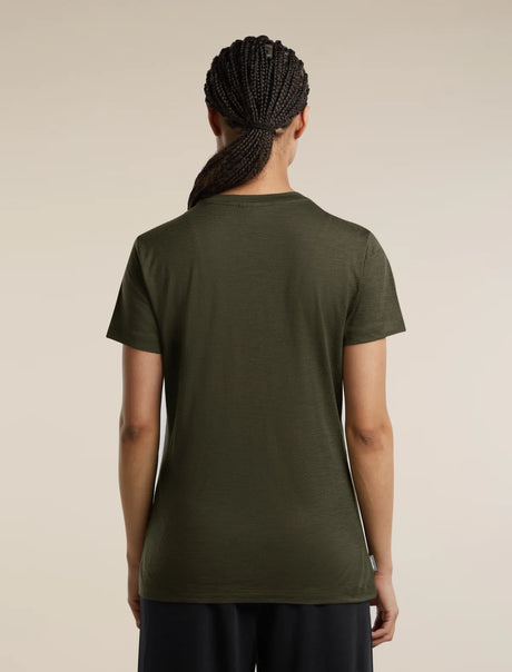A woman viewed from the back wearing a short-sleeve crew-neck t-shirt in olive green, paired with dark pants, against a solid light beige background. - Icebreaker Merino 150 Tech Lite Short Sleeve T-Shirt Bird Transit (Women's) - Dark Loden