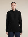 A woman modeling a black long-sleeve quarter-zip athletic pullover against a solid beige studio background. - Icebreaker Merino 400 RealFleece Grid Peaksland Long Sleeve Half Zip (Women's) - Black
