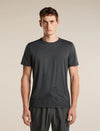 A man wearing a dark gray short-sleeve athletic t-shirt with a subtle mountain line-art graphic near the hem, paired with dark gray athletic pants, against a solid beige background. - Icebreaker Merino 150 Tech Lite Short Sleeve T-Shirt 3D Mapping (Men's) - Obsidian