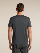 A man viewed from the back wearing a dark charcoal gray short-sleeve t-shirt and matching dark gray pants, set against a plain beige studio background. - Icebreaker Merino 150 Tech Lite Short Sleeve T-Shirt 3D Mapping (Men's) - Obsidian