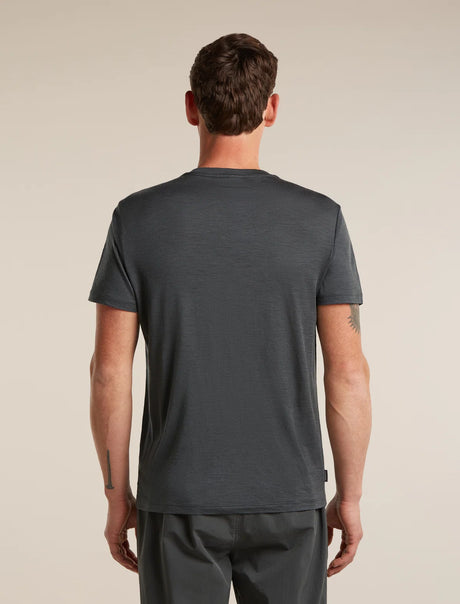 A man viewed from the back wearing a dark charcoal gray short-sleeve t-shirt and matching dark gray pants, set against a plain beige studio background. - Icebreaker Merino 150 Tech Lite Short Sleeve T-Shirt 3D Mapping (Men's) - Obsidian