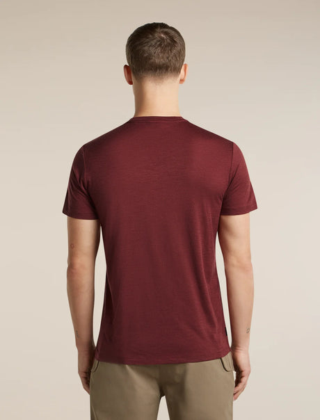 A man viewed from the back wearing a short-sleeve crew-neck t-shirt in maroon and khaki pants, set against a plain beige studio background. - Icebreaker Merino 150 Tech Lite Short Sleeve T-Shirt Getaway (Men's) - Port
