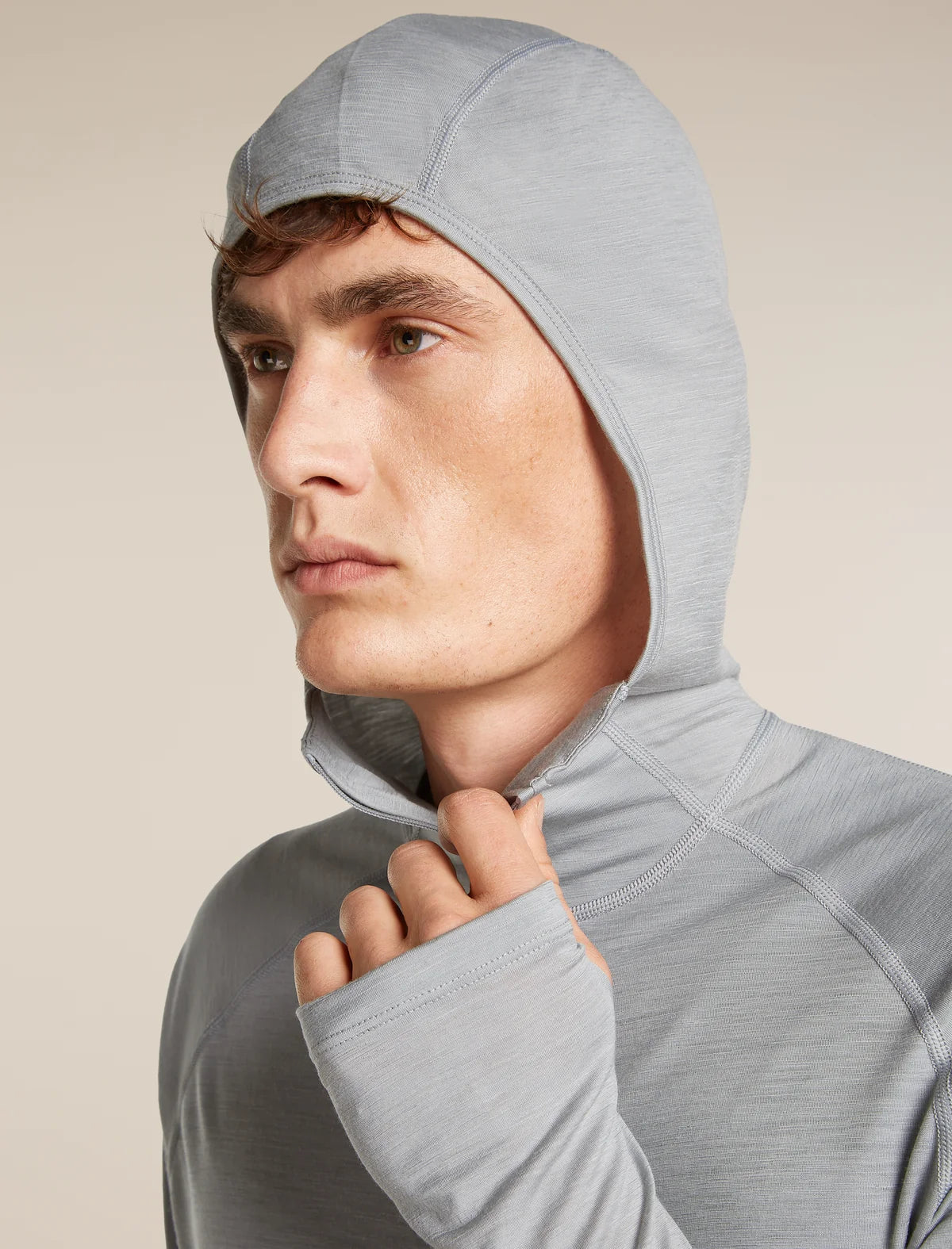 Man wearing a gray hooded outfit against a beige background - Icebreaker 150 MerinoFine Ace Long Sleeve Zip Hoodie (Men's) - Proto Grey