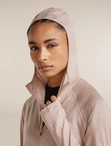 Woman wearing a light pink hoodie against a beige background - Icebreaker 150 MerinoFine Ace Long Sleeve Zip Hoodie (Women's) - Pink Quartz