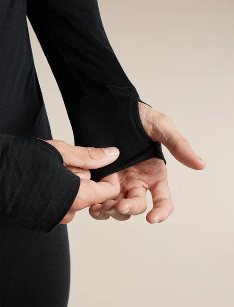 Close-up of a person's hands and wrists wearing a black long-sleeve athletic top with thumbholes, demonstrating the fit and stretch of the cuff. - Icebreaker Merino Blend 200 RealFleece Descender Long Sleeve Half Zip (Men's) - Black