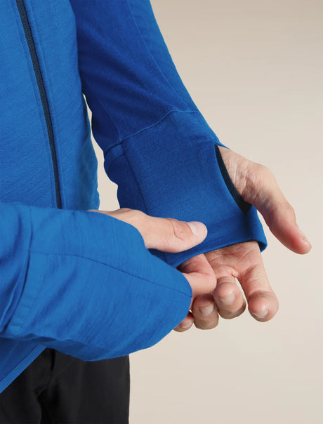 Close-up of a person's hands demonstrating the elastic, stretchable cuff of a bright blue long-sleeve jacket. - Icebreaker Merino Blend 300 RealFleece™ Descender Long Sleeve Zip Hoodie (Men's) - 
Lazurite/Midnight Navy
