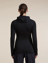 Rear view of a woman wearing a black long-sleeve hooded athletic top and dark pants against a plain beige studio background. - Icebreaker Merino Blend 200 RealFleece Descender Long Sleeve Zip Hoodie (Women's) - Black