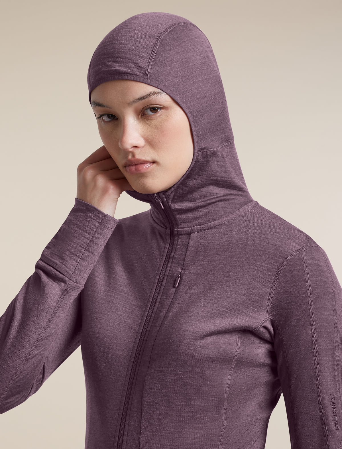 A woman wearing a textured, heathered plum-purple full-zip hooded jacket against a solid beige background. - Icebreaker Merino Blend 200 RealFleece Descender Long Sleeve Zip Hoodie (Women's) - Grey Plum - Purple