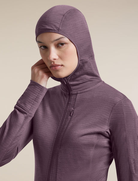 A woman wearing a textured, heathered plum-purple full-zip hooded jacket against a solid beige background. - Icebreaker Merino Blend 200 RealFleece Descender Long Sleeve Zip Hoodie (Women's) - Grey Plum - Purple