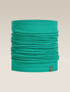 A teal green tubular neck gaiter or face mask, folded to show its layered fabric texture, with a small dark brand tag on the bottom right, set against a solid beige background. - Icebreaker Merino 200 Flexi Chute (Unisex) - Fresh