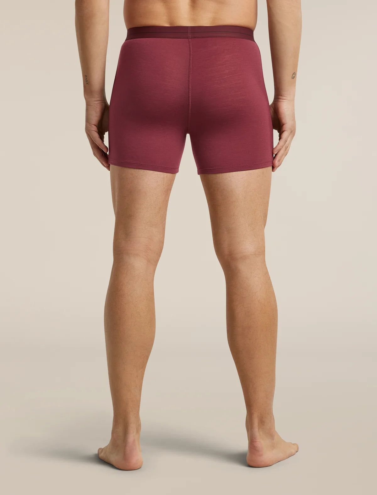 A person shown from the back wearing fitted boxer-brief style shorts in a muted burgundy tone against a plain light beige studio background. - Icebreaker Merino 150 Anatomica Boxers (Men's) - Port