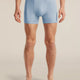 A man wearing light blue Icebreaker boxer briefs, shown from the waist down against a plain beige studio background. - Icebreaker Merino 150 Anatomica Boxers (Men's) - Zinc Blue