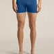 A model from the waist down wearing blue Lebrecker men's boxer briefs, standing against a solid beige studio background. - Icebreaker Merino 150 Anatomica Boxers (Men's) - Lazurite