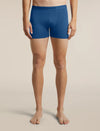 A model from the waist down wearing blue Lebrecker men's boxer briefs, standing against a solid beige studio background. - Icebreaker Merino 150 Anatomica Boxers (Men's) - Lazurite