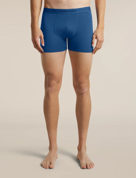 A model from the waist down wearing blue Lebrecker men's boxer briefs, standing against a solid beige studio background. - Icebreaker Merino 150 Anatomica Boxers (Men's) - Lazurite