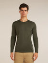 Man wearing a green long-sleeve shirt against a beige background - Icebreaker Merino 200 Oasis Long Sleeve Crew Thermal Top (Men's) - Dark Loden