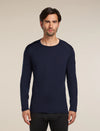 Man wearing a navy long-sleeve shirt against a beige background - Icebreaker Merino 260 Oasis Long Sleeve Crew Thermal Top (Men's) - Midnight Navy