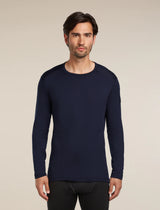 Man wearing a navy long-sleeve shirt against a beige background - Icebreaker Merino 260 Oasis Long Sleeve Crew Thermal Top (Men's) - Midnight Navy