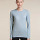 A woman modeling a light blue long-sleeve crewneck athletic top against a solid beige background. - Icebreaker Merino 200 Oasis Long Sleeve Crew Thermal Top (Women's) - Zinc Blue