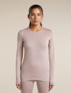 A woman modeling a long-sleeve crewneck top in a dusty mauve-pink color, paired with matching leggings, against a solid light beige background. - Icebreaker Merino 260 Oasis Long Sleeve Crew Thermal Top (Women's) - Pink Quartz