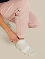 Person wearing light pink pants and white socks on a beige background - Icebreaker Merino Multisport Light Mini Socks (Women's) - Ecru Heather/Alloy