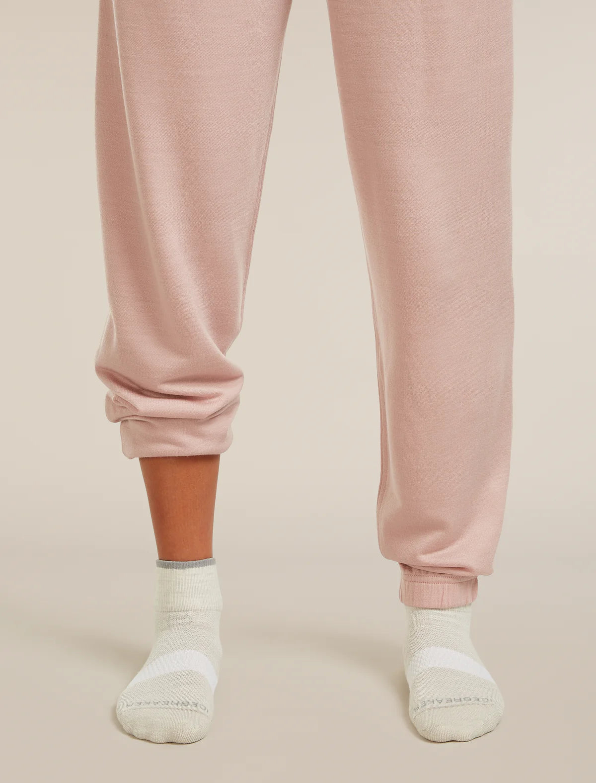 Pink sweatpants worn by a person on a beige background - Icebreaker Merino Multisport Light Mini Socks (Women's) - Ecru Heather/Alloy