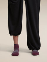 Close-up of a person's lower legs wearing black wide-leg cropped pants and dark burgundy low-cut socks against a light beige studio background. - Icebreaker Merino Multisport Light Mini Socks (Women's) - Dark Berry/Midnight Navy/Grey Plum
