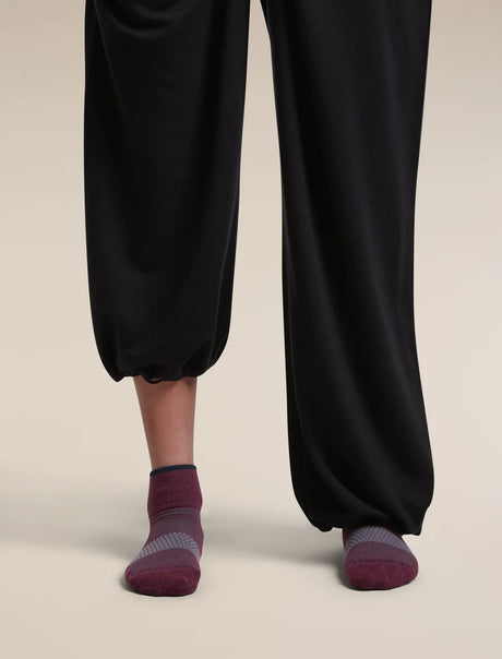 Close-up of a person's lower legs wearing black wide-leg cropped pants and dark burgundy low-cut socks against a light beige studio background. - Icebreaker Merino Multisport Light Mini Socks (Women's) - Dark Berry/Midnight Navy/Grey Plum