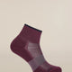 A single low-cut athletic sock in a deep burgundy color with a dark navy blue ribbed cuff and toe, featuring a textured knit pattern on the foot, shown against a solid light beige background. - Icebreaker Merino Multisport Light Mini Socks (Women's) - Dark Berry/Midnight Navy/Grey Plum