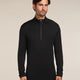 Man wearing a black long-sleeve shirt with a quarter zip on a beige background - Icebreaker Merino 260 Tech Long Sleeve Half Zip (Men's) - Black