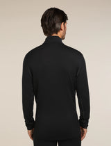 Man wearing a black long-sleeve shirt against a beige background - Icebreaker Merino 260 Tech Long Sleeve Half Zip (Men's) - Black